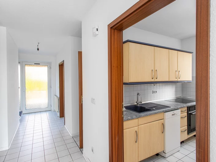 Professionelle Perspektive vom Flur mit Durchblick in die Küche, Fokus auf Raumtiefe und Architekturfotografie Magdeburg.